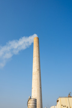 现代工业工厂的巨大烟囱和蓝天