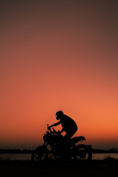 夕阳下骑摩托车的骑手