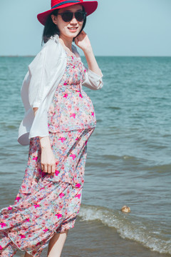怀孕女人出游海边玩沙玩水