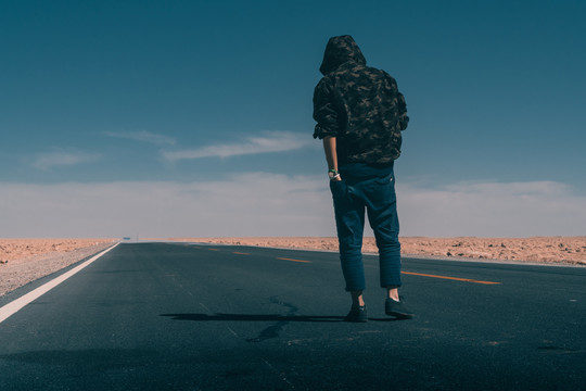 中国西部戈壁荒凉道路自驾男人