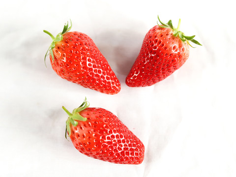 三颗草莓排列白底图