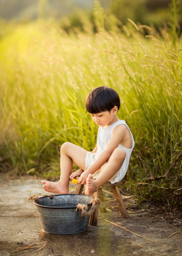 傍晚小男孩在河边洗脚玩耍