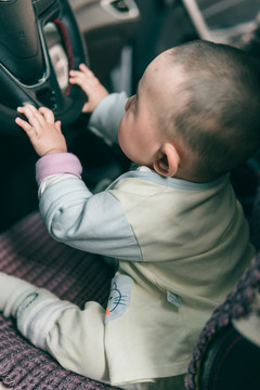 10岁婴儿在汽车里玩耍表情特写