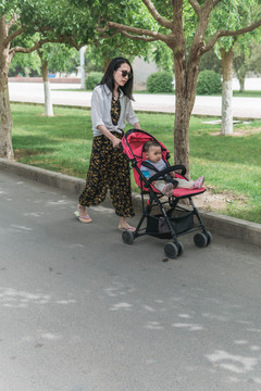母亲带儿童车女儿户外逛街