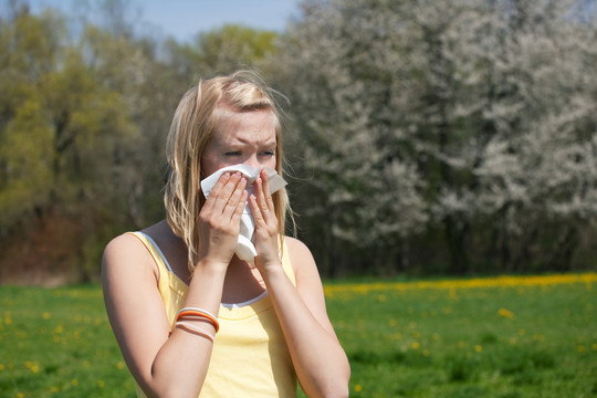 患流感或过敏的妇女在春天对着手帕打喷嚏