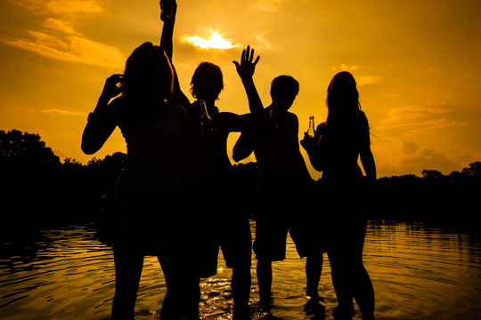 人们在落日的余晖中自由地在水里举行夏日派对