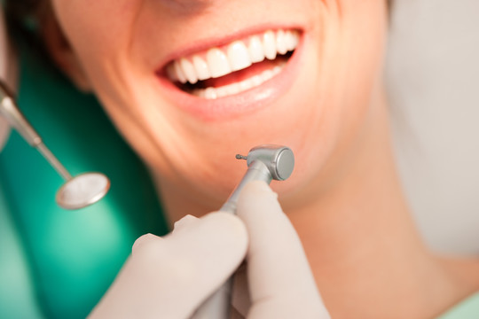 女患者在与牙医进行牙科治疗的过程中，注重钻研