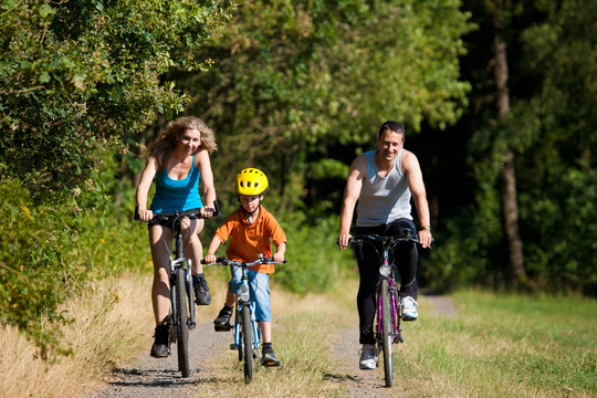 一个夏天，一家人带着孩子骑着自行车，穿着运动装，只关注儿子