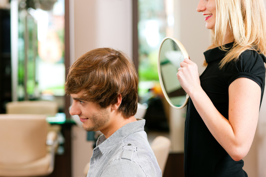 理发店的男人，她已经剪好了，正在镜子里展示结果