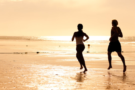 沙滩上慢跑的情侣