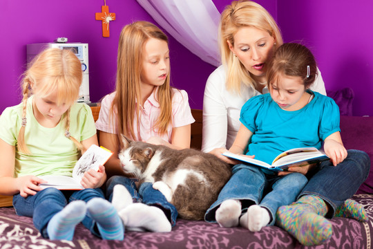 快乐家庭——妈妈正在看书，她和孩子们坐在一间儿童房里