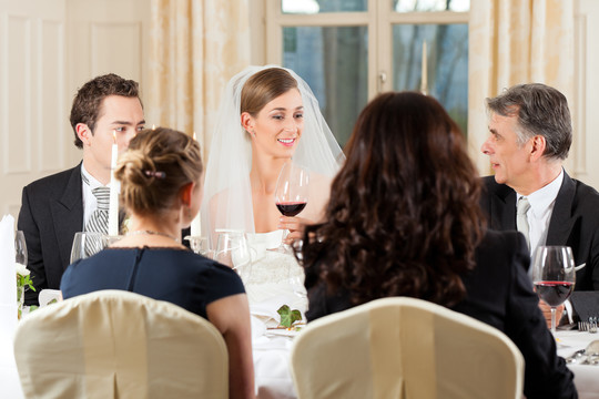 晚宴上的婚礼——新婚夫妇正在用葡萄酒碰杯