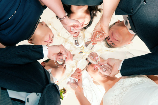 婚礼派对上新娘、新郎和新娘父亲用起泡酒碰杯，光彩照人-特写