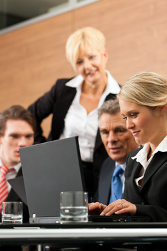 商务团队会议在办公室用笔记本电脑，老板和他的员工