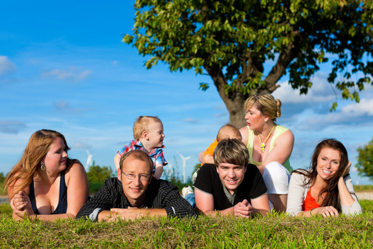 家庭和多代人-母亲，父亲，孩子和祖母在夏天的草地上玩耍