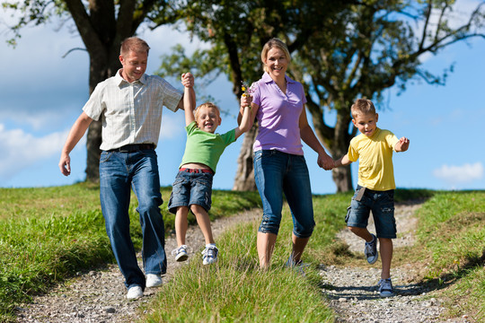 在一个美丽的夏日，快乐的家庭在一条泥泞的小路上奔跑
