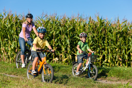 一家人在夏天骑自行车——母亲和两个儿子