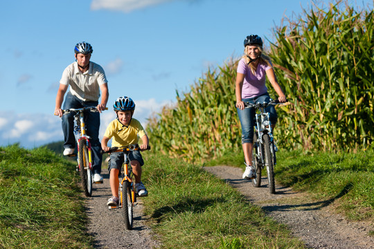 一家人在夏天骑自行车——这里有母亲、父亲和儿子