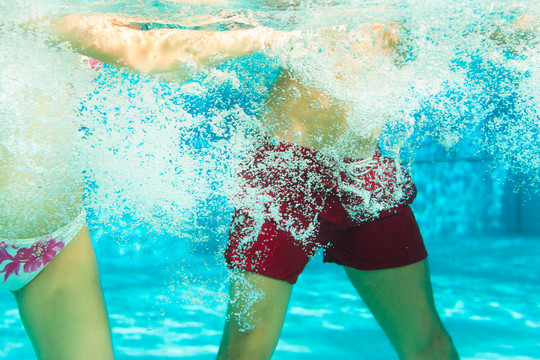 健身-一对年轻夫妇（男男女女）在游泳池或水疗中心的水下做运动和体操或水上有氧运动