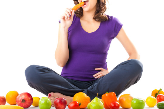 健康的饮食，快乐的女人用水果和蔬菜是吃胡萝卜