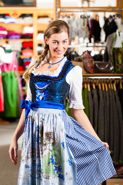 传统服装——年轻女子在商店买Tracht或dirndl，她必须先试穿