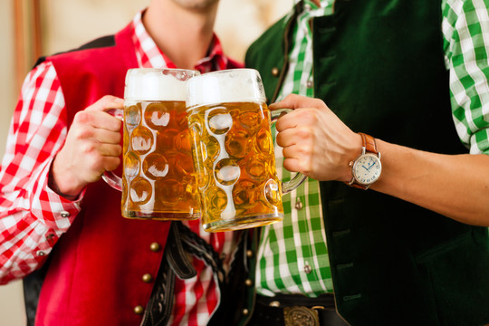 两个年轻人在传统的巴伐利亚州餐厅或酒吧与啤酒和啤酒