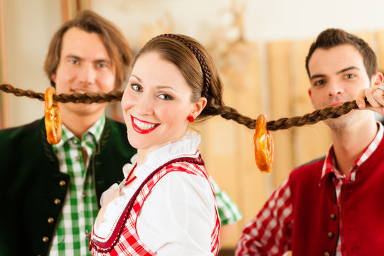 年轻人在传统的巴伐利亚州餐馆或酒吧里玩，开玩笑