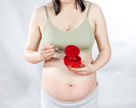 年轻孕妇手上拿着红心火龙果