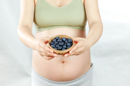 年轻孕妇手上端着蓝莓