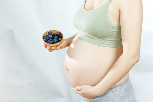 年轻孕妇手上端着蓝莓