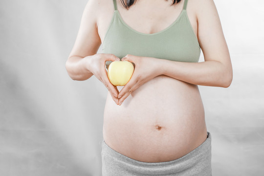 孕妇手上拿着一个奶油苹果