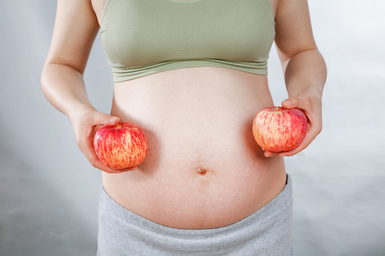 孕妇手上拿着两个苹果