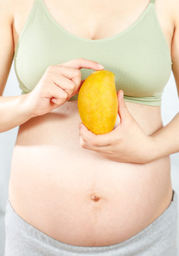年轻孕妇手上拿着芒果