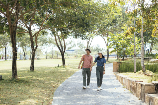 一对戴着同一顶帽子的亚泰夫妇在公园散步。旅行者夫妇在公园里旅行。
