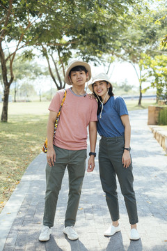一对戴着同一顶帽子的亚泰夫妇在公园散步。旅行者夫妇在公园里旅行。
