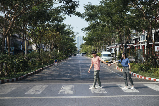 亚泰夫妇手牵斑马线过马路。