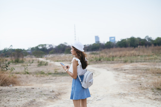 美丽的亚泰旅行家女人迷路了。她用智能手机上的GPS地图想办法离开这里。