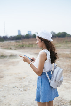 美丽的亚泰旅行家女人迷路了。她用智能手机上的GPS地图想办法离开这里。