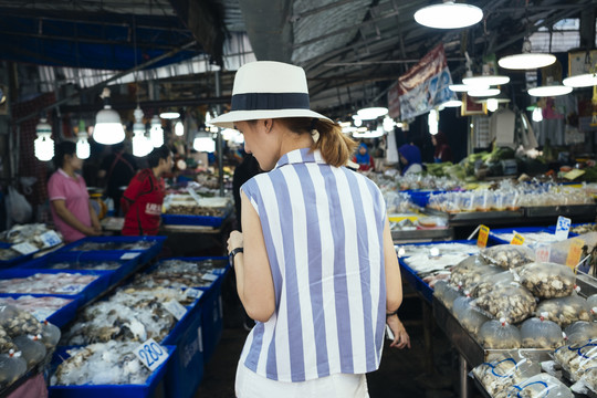 在当地市场寻找海鲜的女游客。