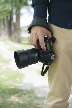 当男摄影师拿着数码相机的照片在他身后的复印空间。