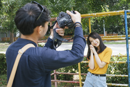 摄影师和女模特在操场上合影。