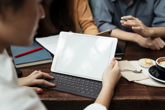 三个年轻的商务人士在会议上使用笔记本电脑。复制平板电脑上的空间。技术涉及到每一个行业。