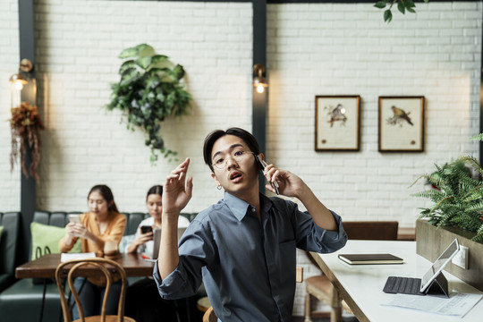 一个年轻的亚洲商人打电话来这里和人交谈。