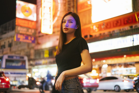 时尚写真-穿着黑色衬衫和牛仔裤的亚洲时髦年轻女子。城市夜生活。夜间肖像。