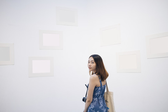 在白色美术馆，一位身着蓝色礼服的泰国亚裔年轻女子。
