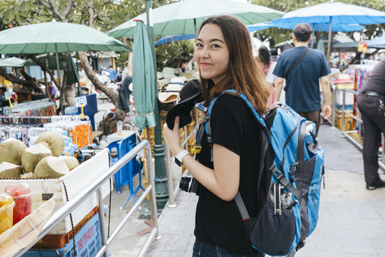 背包客喜欢在泰国当地市场街上寻找食物。