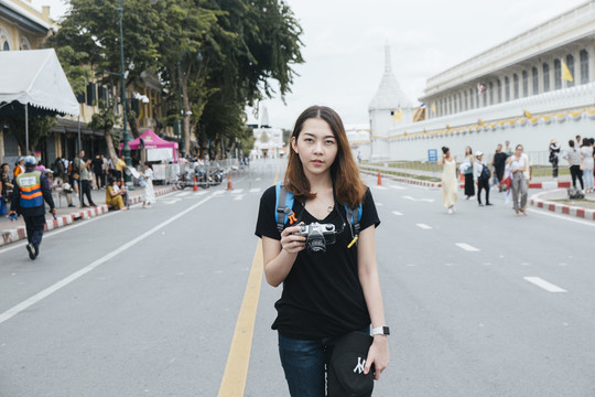 在曼谷旅游的亚洲年轻女子站在wat arun地区附近的公路上的肖像。