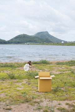年轻的泰国亚裔女子嬉皮卷发白色连衣裙玩沙滩在湖上。盒子外面的女孩。