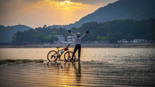 夕阳湖泊骑行少年