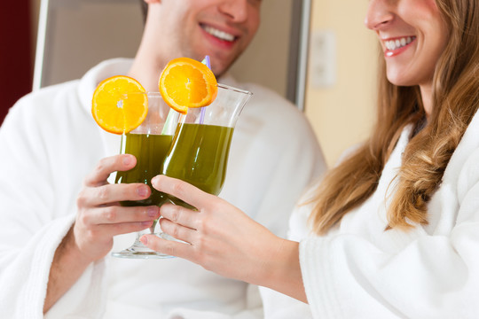 一对年轻夫妇-男人和女人-在水疗中心喝叶绿素奶昔